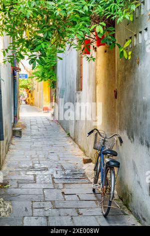 Vélo garé près du mur de la vieille maison sur la rue étroite pittoresque de Hoi an Ancient Town (Hoian), Vietnam. Banque D'Images