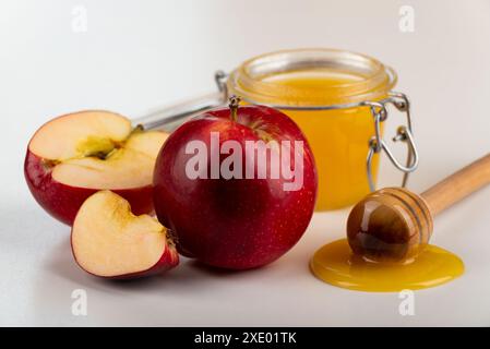 Pot Mason avec un pot au miel et des pommes rouges sur une table de cuisine Banque D'Images