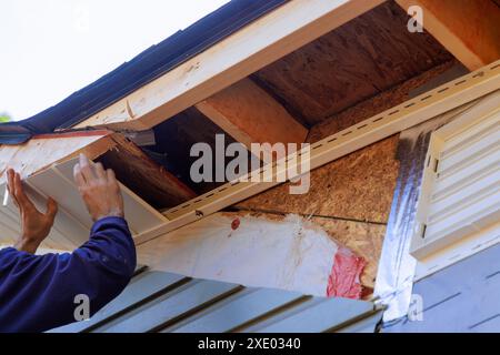 Sous le toit de la maison, des panneaux de soffite en vinyle blanc uPVC ont été installés le long de la ligne de toit. Banque D'Images
