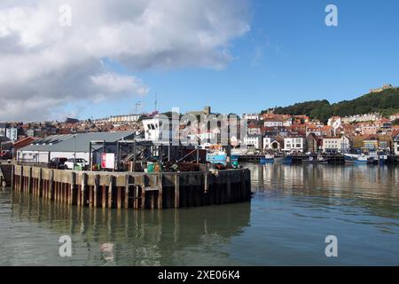 Vue sur l'entrée du port de scarborough en été avec des bateaux de pêche amarrés à côté des bâtiments de la ville Banque D'Images