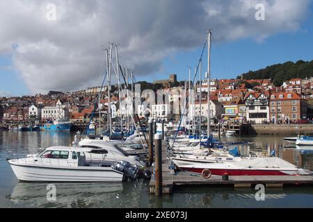 Bateaux de loisirs et yachts amarrés dans la zone de la marina du port de scarborough avec la ville au loin Banque D'Images