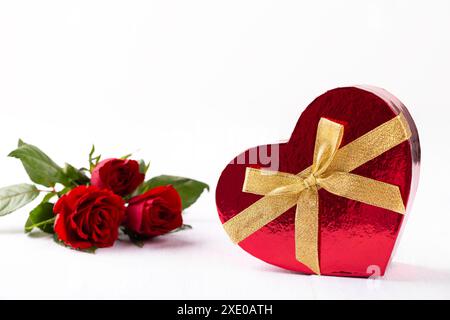 Boîte cadeau en forme de coeur et bouquet de roses rouges Banque D'Images