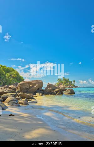 Anse royale plage, Mahé, bleu ciel eau turquoise, marée basse journée ensoleillée, plage de sable blanc et rochers de granit, Seychelles Banque D'Images