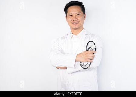 Un homme en blouse blanche sourit et tient un stéthoscope. Concept de professionnalisme et de confiance, comme l'homme pose pour une photo pendant que nous Banque D'Images