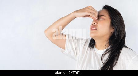 Une femme au nez qui coule. Femme asiatique souffrant de nez bouché ayant le nez qui coule et la mauvaise haleine causée par l'infection des sinus. Banque D'Images