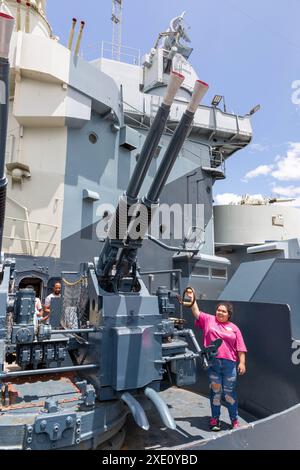 Wilmington, NC/USA - 22 juin 2024 : un visiteur du parc déplace les canons anti-aériens l-60 Bofors de 40 mm sur le côté bâbord du cuirassé USS North Carolina. Banque D'Images