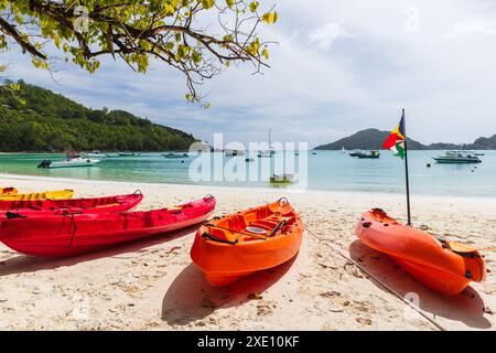 Paysage de plage d'été avec kayaks en plastique rouge et drapeau des Seychelles par une journée ensoleillée Banque D'Images