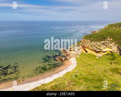 Côte de Hopeman Moray Firth Écosse petite crique et plage avec falaise de grès doré et mer bleu vert Banque D'Images