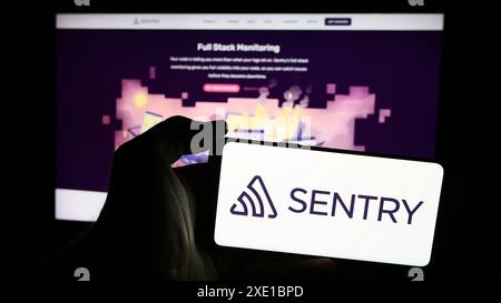 Personne tenant le téléphone portable avec le logo de la société américaine Functional Software Inc (Sentry) devant la page Web de l'entreprise. Concentrez-vous sur l'affichage du téléphone. Banque D'Images