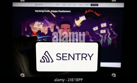 Personne tenant le téléphone portable avec le logo de la société américaine Functional Software Inc (Sentry) devant la page Web de l'entreprise. Concentrez-vous sur l'affichage du téléphone. Banque D'Images