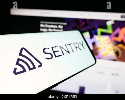 Téléphone portable avec le logo de la société américaine Functional Software Inc (Sentry) devant le site Web de l'entreprise. Focus à gauche de l'écran du téléphone. Banque D'Images