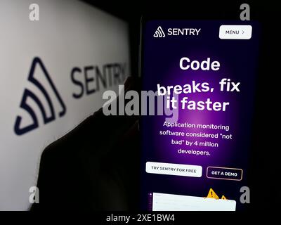 Personne tenant le téléphone portable avec la page Web de la société américaine Functional Software Inc (Sentry) devant le logo. Concentrez-vous sur le centre de l'écran du téléphone. Banque D'Images