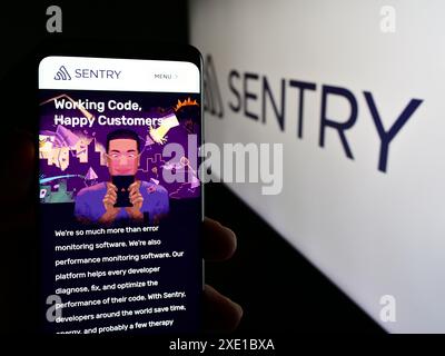 Personne tenant le téléphone portable avec la page Web de la société américaine Functional Software Inc (Sentry) devant le logo. Concentrez-vous sur le centre de l'écran du téléphone. Banque D'Images