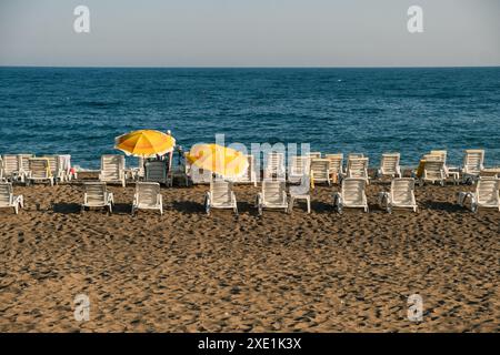 Parasols et chaises longues dans l'état assemblé sur la plage. Banque D'Images
