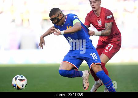 La française Kylian Mbappe (à gauche) est retirée par la polonaise Nicola Zalewski lors du match du Groupe d de l'UEFA Euro 2024 au BVB Stadion Dortmund à Dortmund, en Allemagne. Date de la photo : mardi 25 juin 2024. Banque D'Images