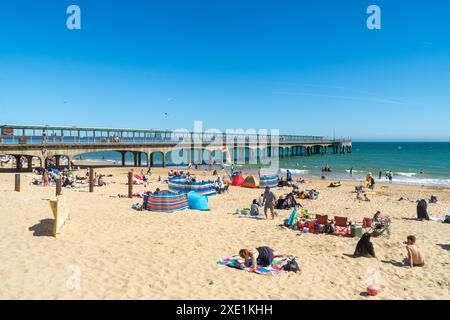 Boscombe, Royaume-Uni - 23 juin 2024 : bains de soleil sur Boscombe Pier Beach à côté de Boscombe Pier. Banque D'Images