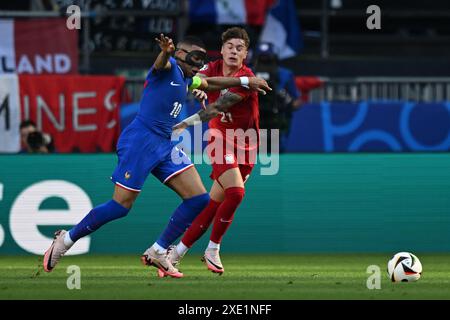 Dortmund, Allemagne. 25 juin 2024. Football, UEFA Euro 2024, Championnat d'Europe, France - Pologne, tour préliminaire, groupe d, jour 3 du match, stade de Dortmund, le Français Kylian Mbappe et le Polonais Nicola Zalewski (R) se battent pour le ballon. Crédit : Bernd Thissen/dpa/Alamy Live News Banque D'Images