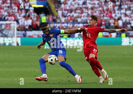 Dortmund, Allemagne. 25 juin 2024. Football, UEFA Euro 2024, Championnat d'Europe, France - Pologne, tour préliminaire, groupe d, jour 3 du match, stade de Dortmund, le Français Kylian Mbappe et le Polonais Nicola Zalewski (R) se battent pour le ballon. Credit : Friso Gentsch/dpa/Alamy Live News Banque D'Images