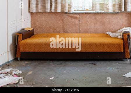 Un vieux canapé dans une maison abandonnée Banque D'Images