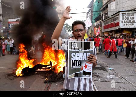 Kolkata, Inde. 25 juin 2024. Un activiste protestant pendant que des pneus et une brûlure effigie brûlent lors d'une manifestation contre la récente arnaque dans NEET et UGC-net examen. Des étudiants de nombreux partis politiques ont protesté contre des irrégularités présumées du gouvernement. Le 25 juin 2024 à Kolkata, Inde. (Photo de Dipa Chakraborty/ crédit : Eyepix Group/Alamy Live News Banque D'Images