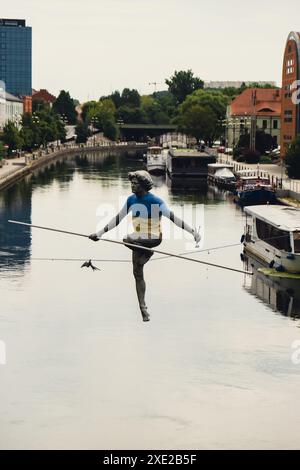 Bydgoszcz, Pologne - août 2022 Rivière Brda à Bydgoszcz Homme traversant une sculpture de rivière , d'un homme en équilibre sur un fil de fer, vieux grana Banque D'Images