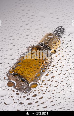 Un flacon de gel cosmétique avec une pipette sur fond de gouttes. Banque D'Images