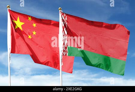 Drapeau chinois et drapeau biélorusse sur ciel nuageux. voler dans le ciel Banque D'Images