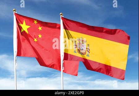 Drapeau chinois et drapeau espagnol sur ciel nuageux. ondulant dans le ciel Banque D'Images