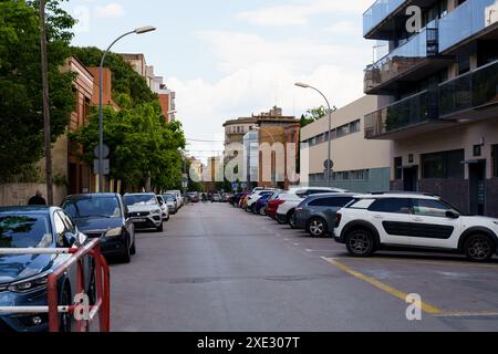 Figueres, Espagne - 14 mai 2023 : une rangée de voitures garées le long d'une rue animée de la ville avec des bâtiments en arrière-plan. Banque D'Images