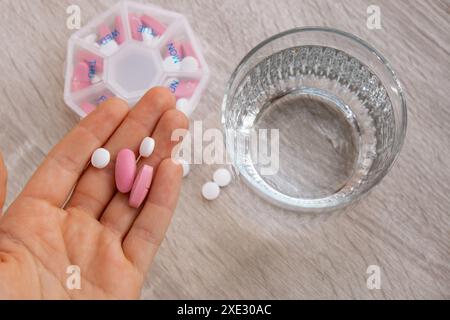 Femme tri Pills Organizer tirs hebdomadaires gros plan de boîte à pilules médicales avec des doses de comprimés pour prendre quotidiennement des médicaments avec du blanc Banque D'Images