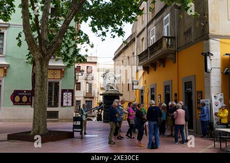 Figueres, Espagne - 14 mai 2023 : un groupe diversifié d'individus debout dans une cour, discutant et interagissant les uns avec les autres sous le ciel ouvert. Banque D'Images