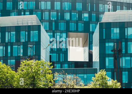 Extérieur commercial en verre moderne de l'architecture d'immeuble de bureaux. Bâtiment abstrait couvert de fenêtres avec des arbres verts à l'avant. Co Banque D'Images