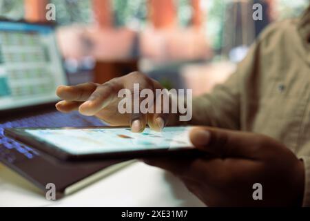 Entrepreneur examinant les rapports de ventes et les statistiques sur une tablette, faisant du travail à distance pour aider à augmenter l'activité de l'entreprise. Jeune gestionnaire conseiller travaillant sur la croissance économique, la gestion de l'argent. Banque D'Images