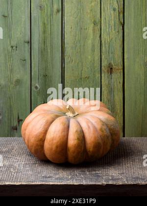 Winter Squash Musquee de Provence Pumpkin ou Fairytale Pumpkin sur une vieille table en bois avec fond vert Banque D'Images