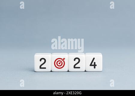 2024 concept de plan d'affaires ou d'objectif. numéro 2024 et icône de cible de but sur les blocs isolés sur fond bleu. Espace de copie Banque D'Images