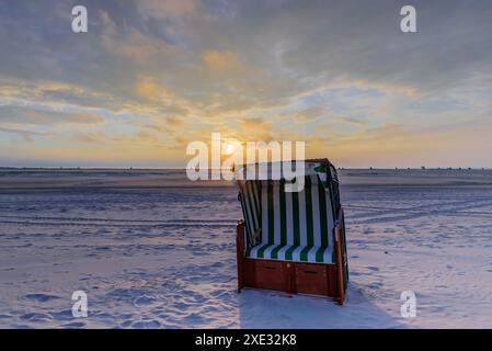 Chaises de plage en osier couvertes sur la plage de sable sur la mer du Nord. Banque D'Images