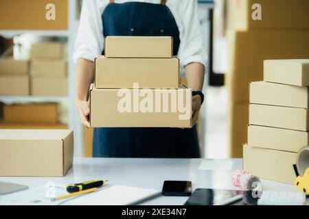 Jeune femme d'affaires travaillant en ligne e-commerce shopping à sa boutique. Banque D'Images