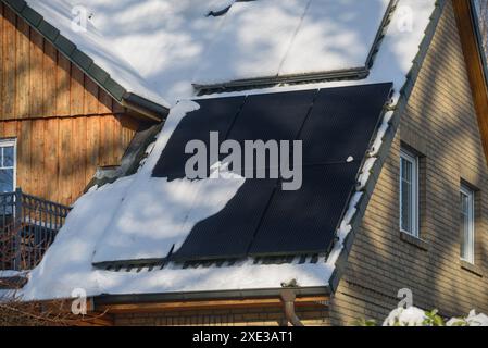 Chauffe-eau solaire et centrale solaire sur un toit de maison résidentielle couverte de neige. Solar the Banque D'Images