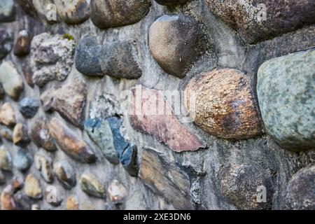 Gros plan sur le mur de pierre varié avec le Boulder de couleur rouille Banque D'Images