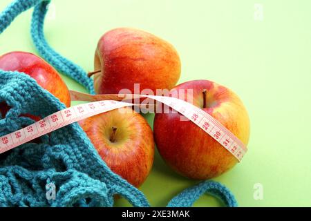 Mètre de mesure et un sac de shopping String réutilisable, sac ouvert en filet avec des pommes rouges fraîches. Magasin de maille Banque D'Images