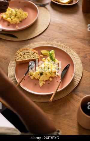 Appréciant le petit déjeuner, couple afro-américain avec œufs brouillés, avocat et pain grillé Banque D'Images