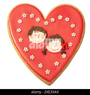Biscuit de coeur rouge Valentines décoré avec la tête de garçon et de fille isolé sur fond blanc Banque D'Images