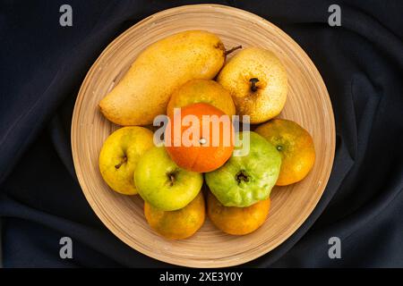 Pile de vue de dessus de divers fruits tropicaux mûrs doux dans un plateau en bambou. Banque D'Images