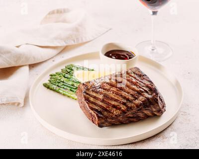 Steak de viande grillé sur assiette avec citron et asperges Banque D'Images