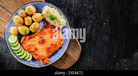Côtelettes panées de porc enrobées de chapelure servie avec des pommes de terre et du chou Banque D'Images