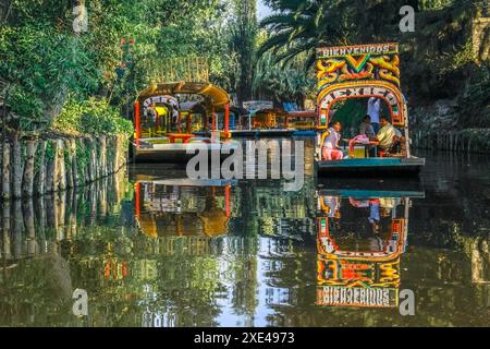 Mexico, Mexique. 11 janvier 2024. Un couple de trajinera a bateaux de style gondole, ou des radeaux colorés glissant le long du Xochimilco Banque D'Images