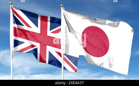 Drapeaux du Japon et de la Grande-Bretagne contre ciel nuageux. ondulant dans le ciel Banque D'Images