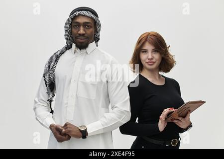 Entrepreneur arabe et une femme d'affaires, exsudant la confiance et l'unité, posent ensemble sur un fond blanc propre, symbolisant Banque D'Images