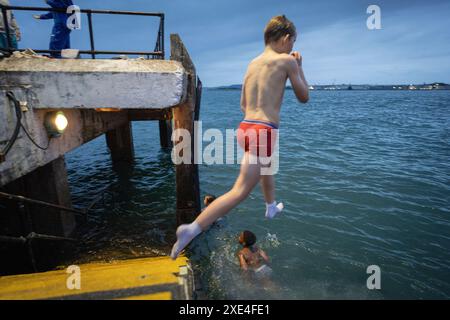 Enfants sautant dans la mer, Cobh, port de Cork, comté de Cork, Irlande, Royaume-Uni Banque D'Images