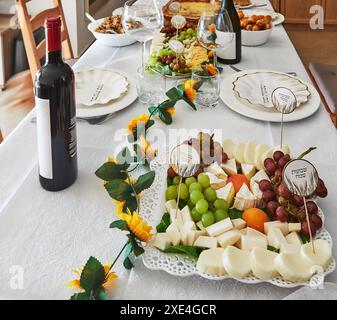 Une élégante table de vacances Shavuot avec du vin, du fromage, des fruits et des décorations de vacances, prête pour un repas de vacances juif traditionnel. Joyeux Shavuot inscript Banque D'Images